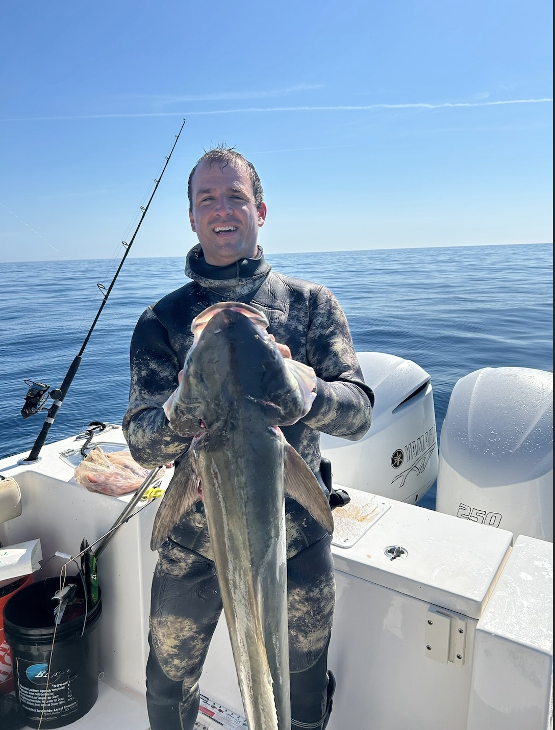 Spearfisher on a boat holding a large cobia caught offshore